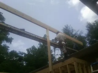 Carpenter setting a ridge beam over a new addition frame — Ice Dam Removal by Roofing Brothers in Villanova