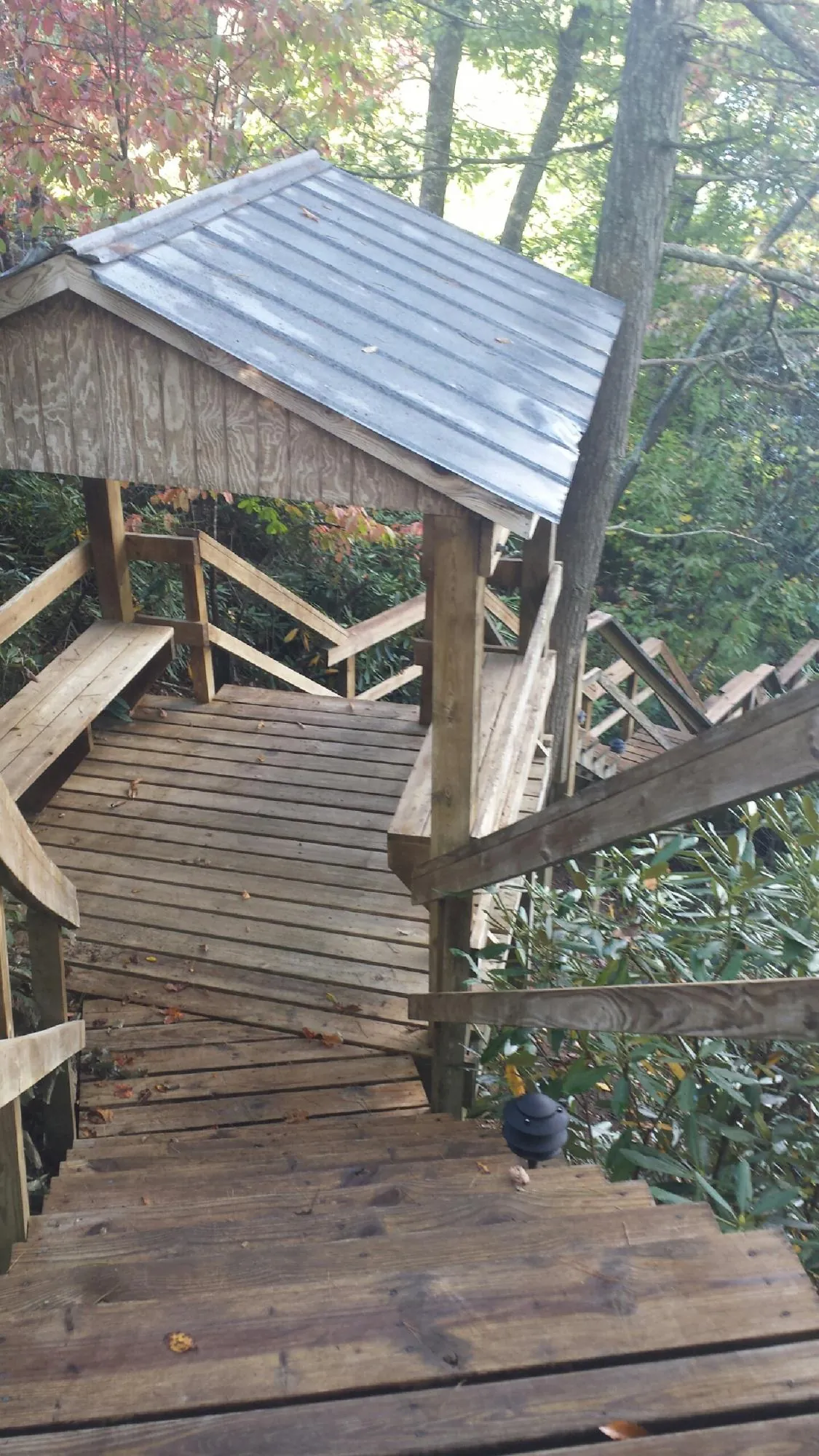 Metal roofed shelter over wooden steps on a wooded walkway — Skylight Repair & Installation work by our crew in Villanova