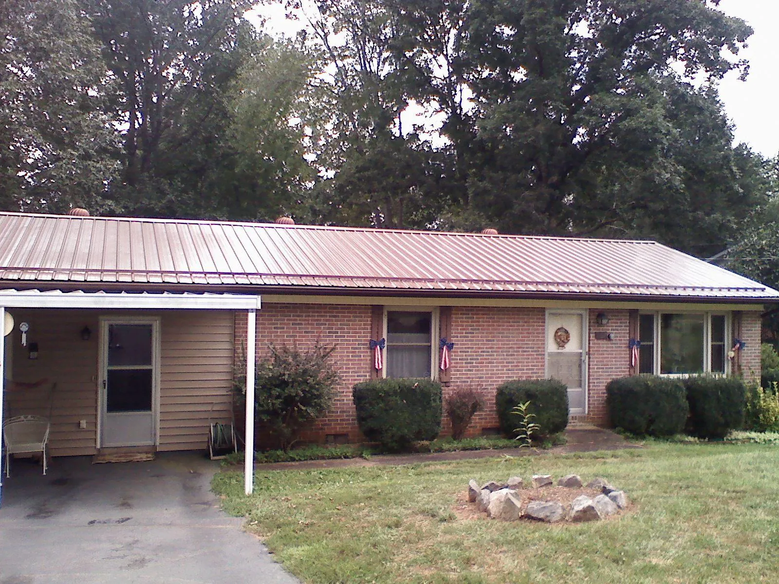 Bronze metal roof and carport on a brick ranch home — Roof Repair work by our crew in Villanova